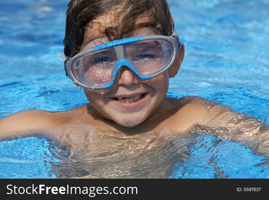 A young boy in pool with goggles on. A young boy in pool with goggles on