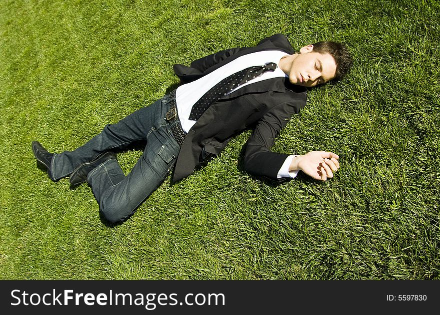 Businessman resting over the grass. Businessman resting over the grass