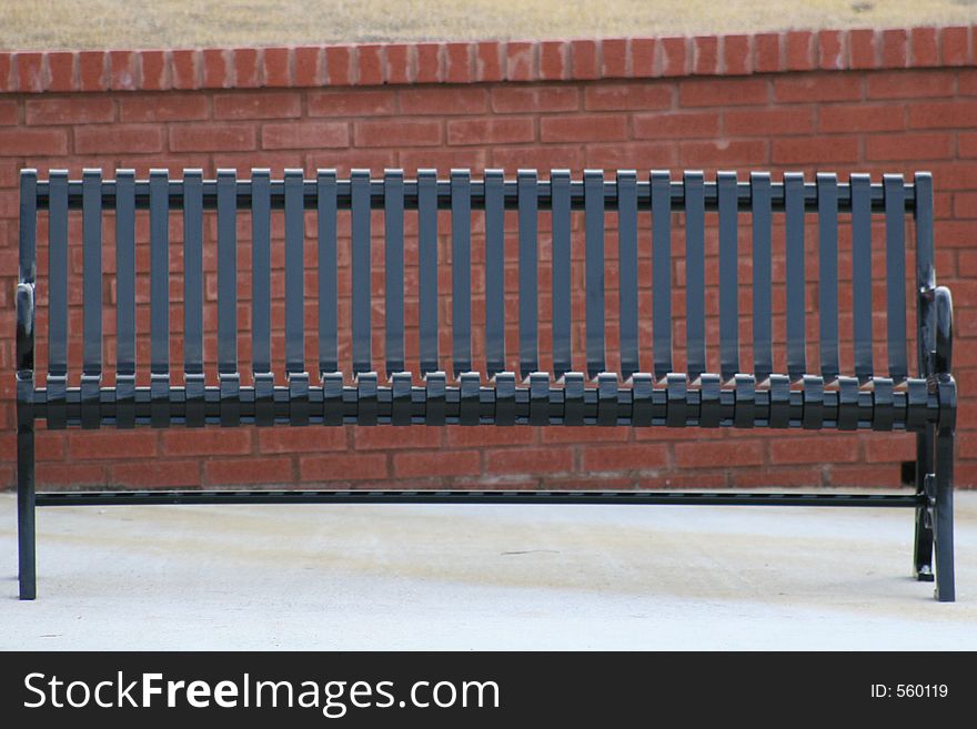 Park bench against brick wall