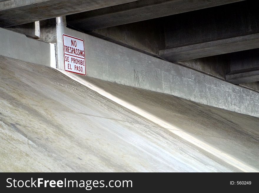 A no tresspassing sign under a bridge formerly inhabited by homeless transients. A no tresspassing sign under a bridge formerly inhabited by homeless transients.