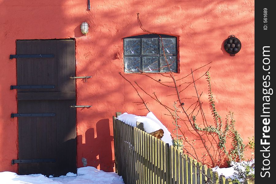 door and window of a red stable in winter