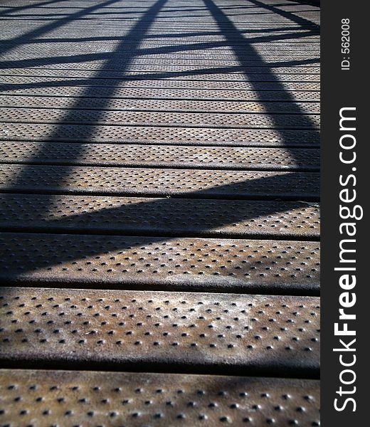 Shadows on a bridge made of metal. Shallow depth of field. Shadows on a bridge made of metal. Shallow depth of field.