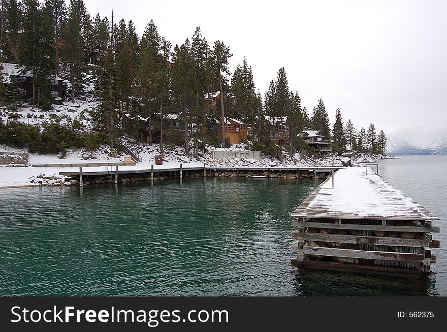 Dock on Lake Tahoe with view of cabins along the shoreline. Dock on Lake Tahoe with view of cabins along the shoreline.