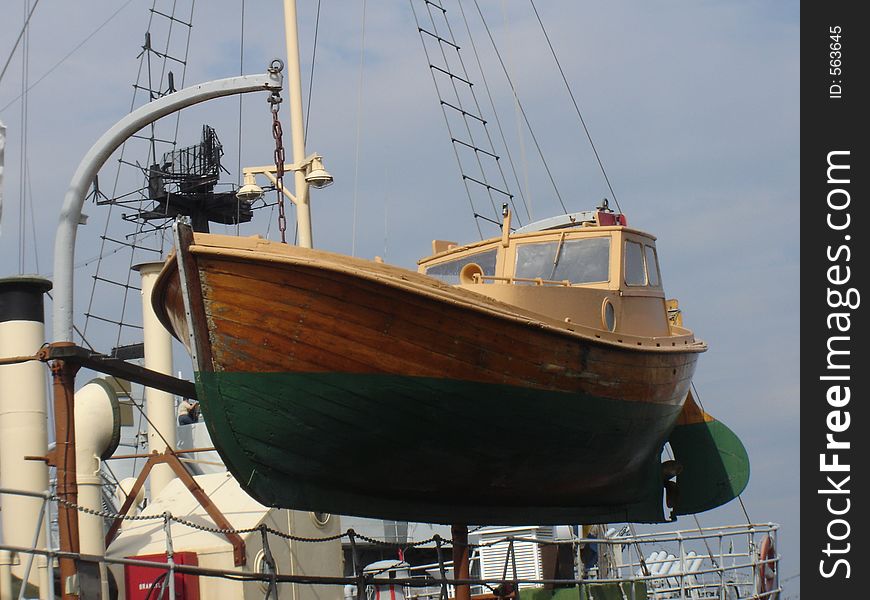 A boat hanging in the air off a ship. A boat hanging in the air off a ship.