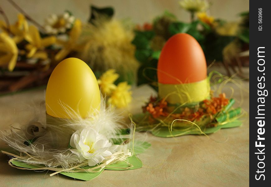 Easter eggs at cardboard holders, flower arrangement at background. Easter eggs at cardboard holders, flower arrangement at background