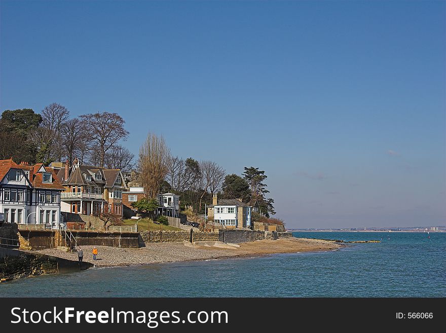 Homes next to beach with blue sea & sky on sunny day. Homes next to beach with blue sea & sky on sunny day