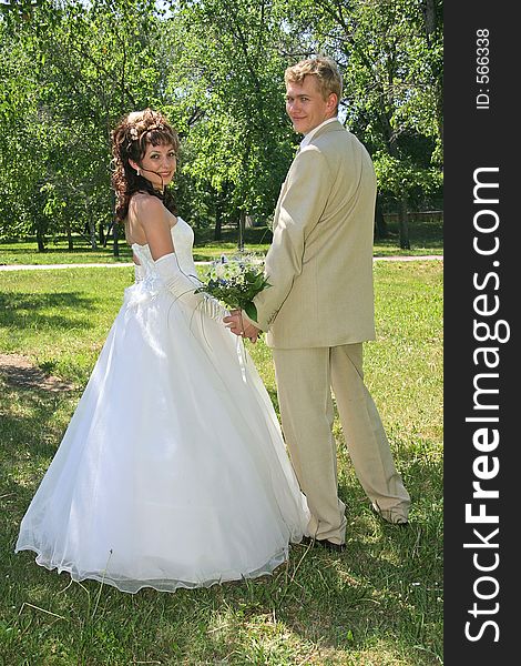 Portrait newlyweds on lawn in park. Portrait newlyweds on lawn in park