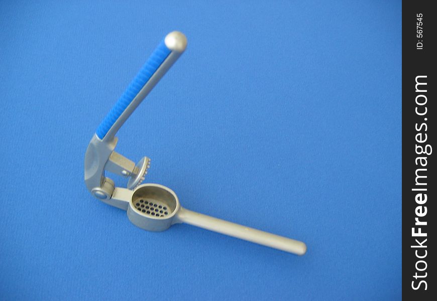 Garlic press on blue background