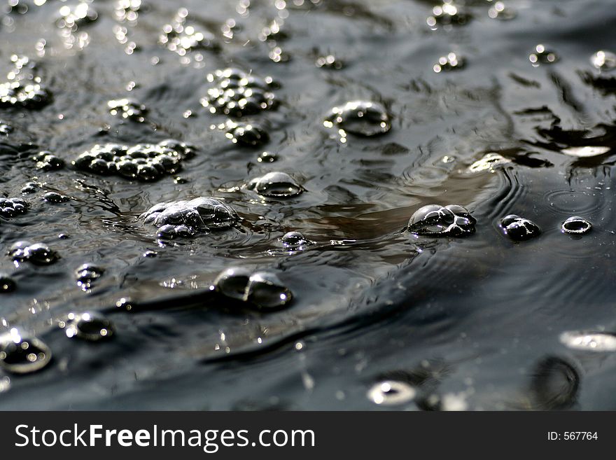 Water flowing by with bubbles on the surface