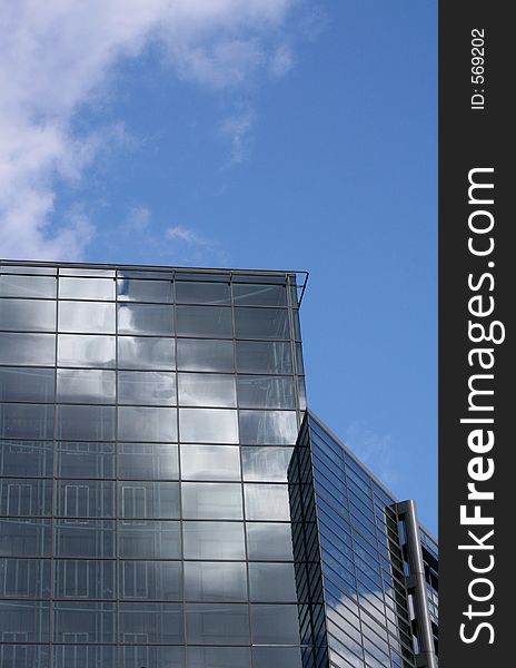 Image of the reflection of a modern office building with the clouds seemingly mirrored in the sky. Image of the reflection of a modern office building with the clouds seemingly mirrored in the sky