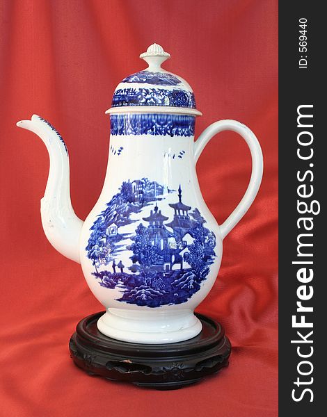 Antique teapot in red background