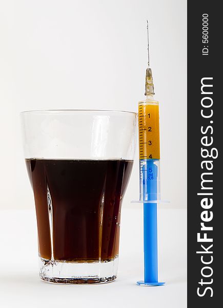 Glass of cola with syringe. Glass of cola with syringe