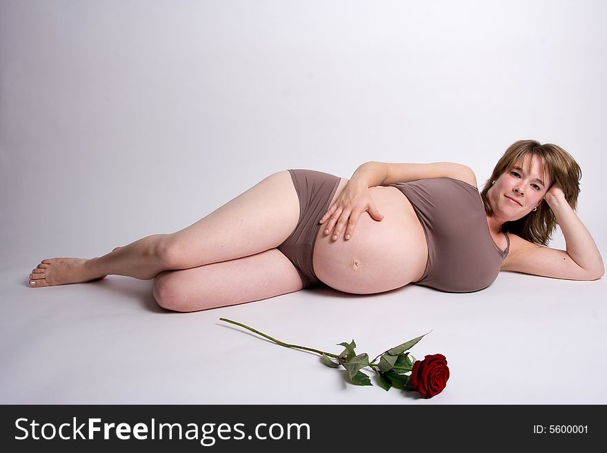 A pregnant woman lying on her side with a rose in front of her. A pregnant woman lying on her side with a rose in front of her.
