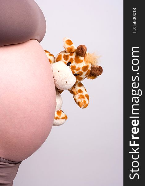A camel toy that is watching the belly of a pregnant woman. A camel toy that is watching the belly of a pregnant woman