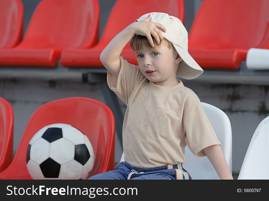 The boy with a toy on empty tribunes of stadium. The boy with a toy on empty tribunes of stadium
