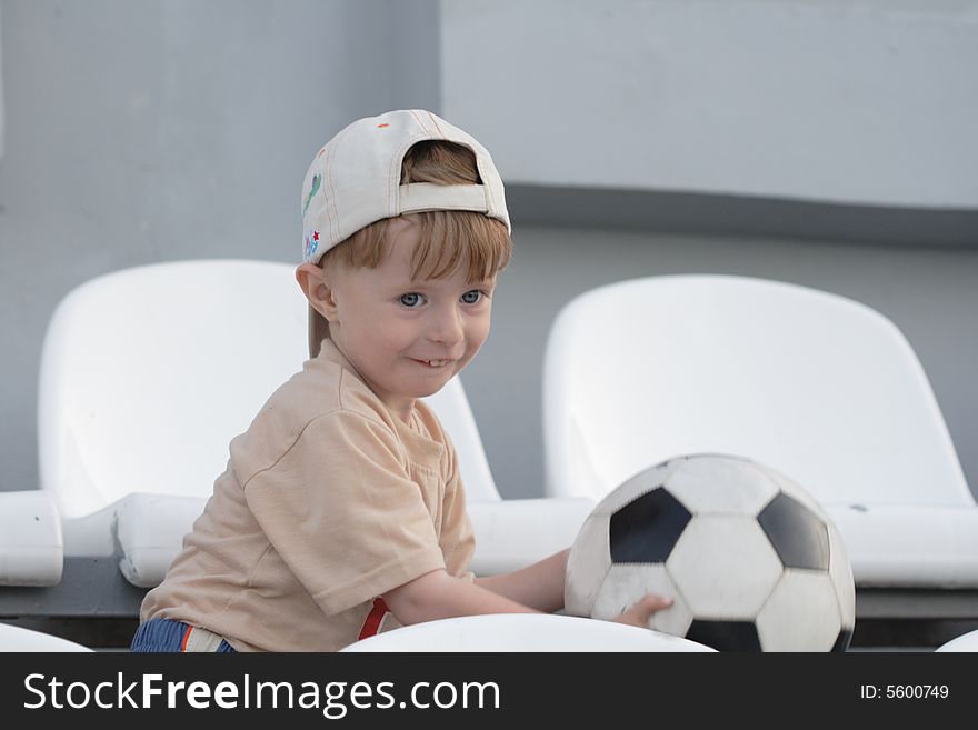 The boy with a toy on empty tribunes of stadium. The boy with a toy on empty tribunes of stadium