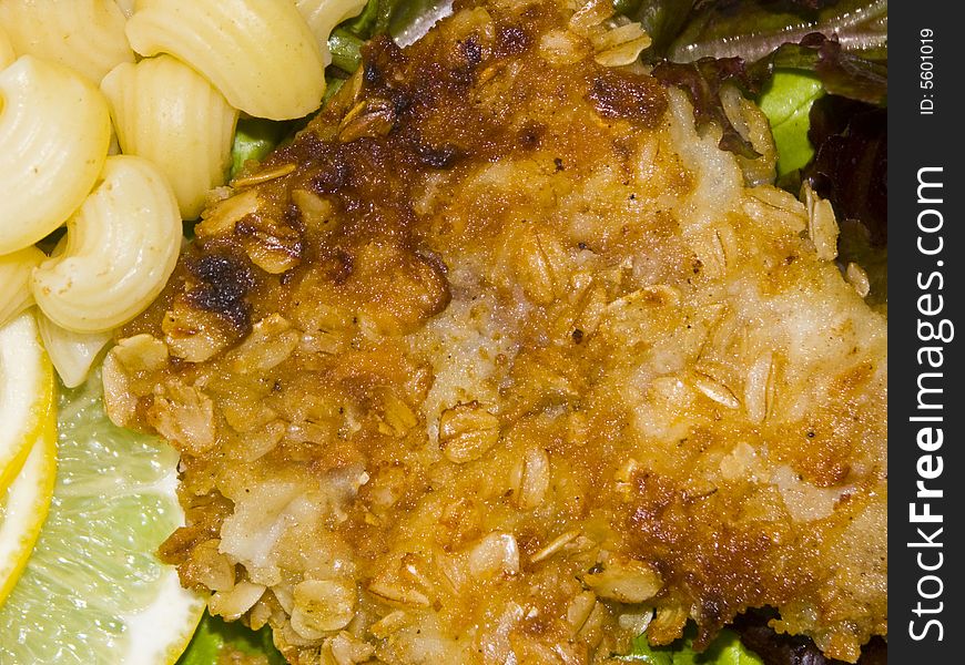 The image of macaroni of a fish and slices of a lemon close up. The image of macaroni of a fish and slices of a lemon close up