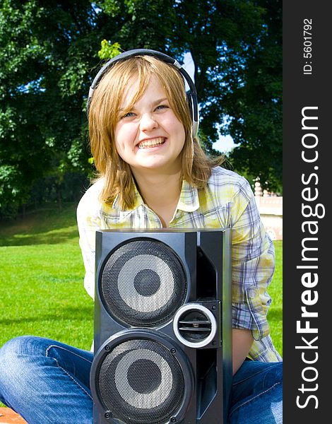 The young attractive girl with headphones and speaker