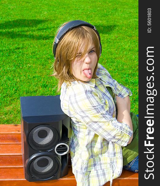 The young attractive girl with headphones and speaker