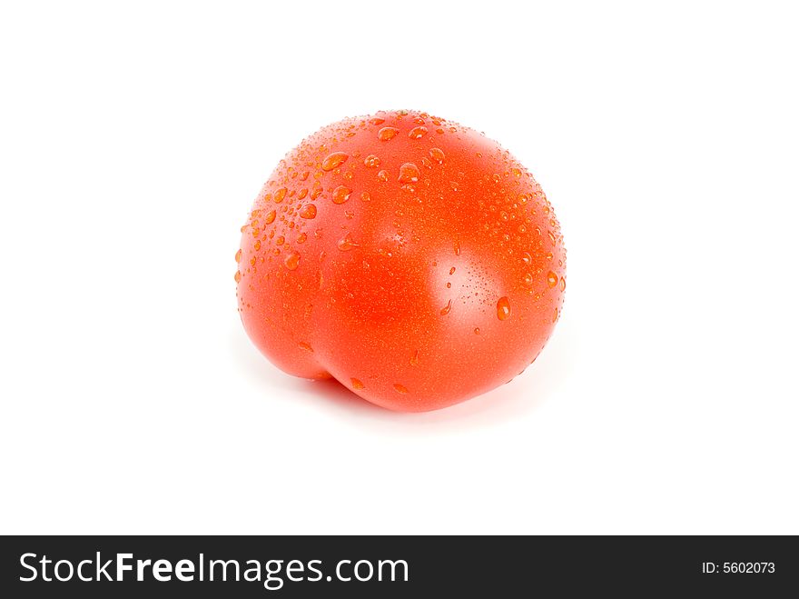 Single ripe tomato with drops of water isolated on the white background