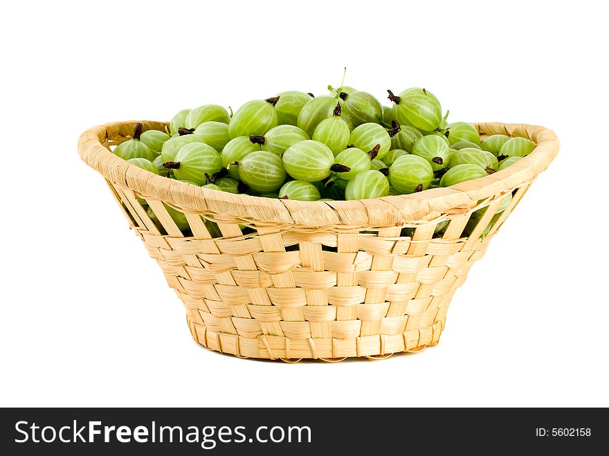 Wicker basket filled with green gooseberries isolated on the white background