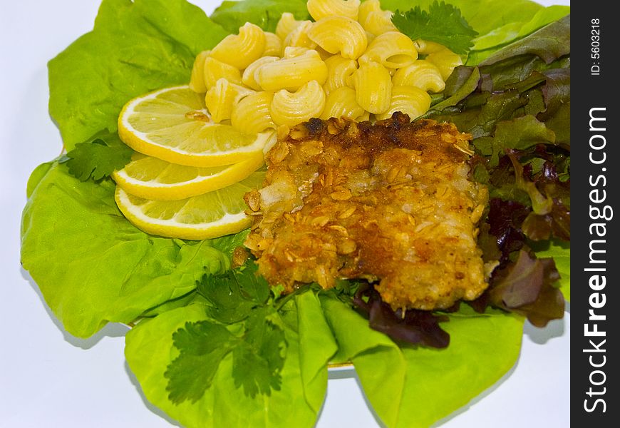 The image of macaroni of a fish and slices of a lemon close up. The image of macaroni of a fish and slices of a lemon close up