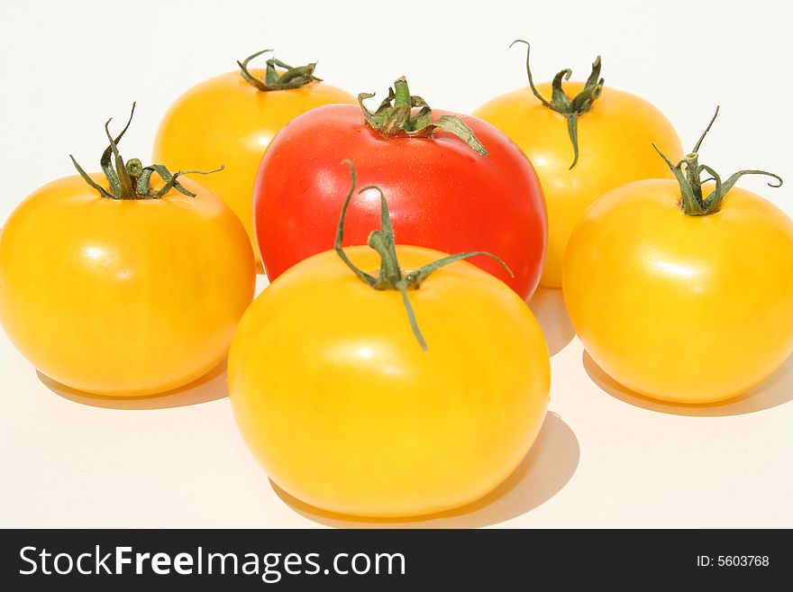 Yellow and red tomatoes against a white background
