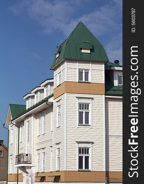 New wooden house with corner tower and tin roof