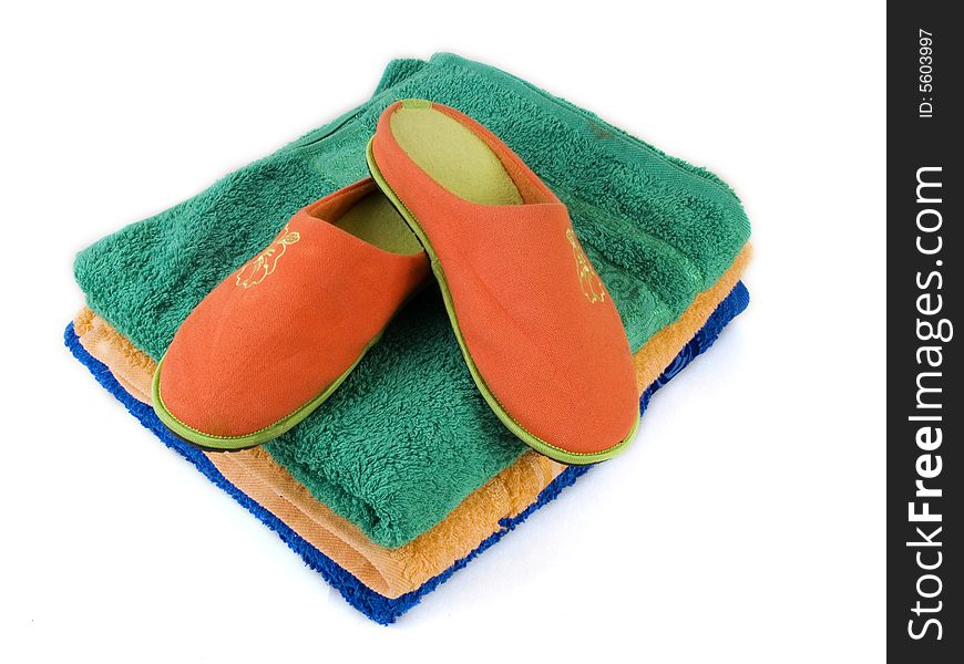 Orange carpet slippers and folded towels. Orange carpet slippers and folded towels