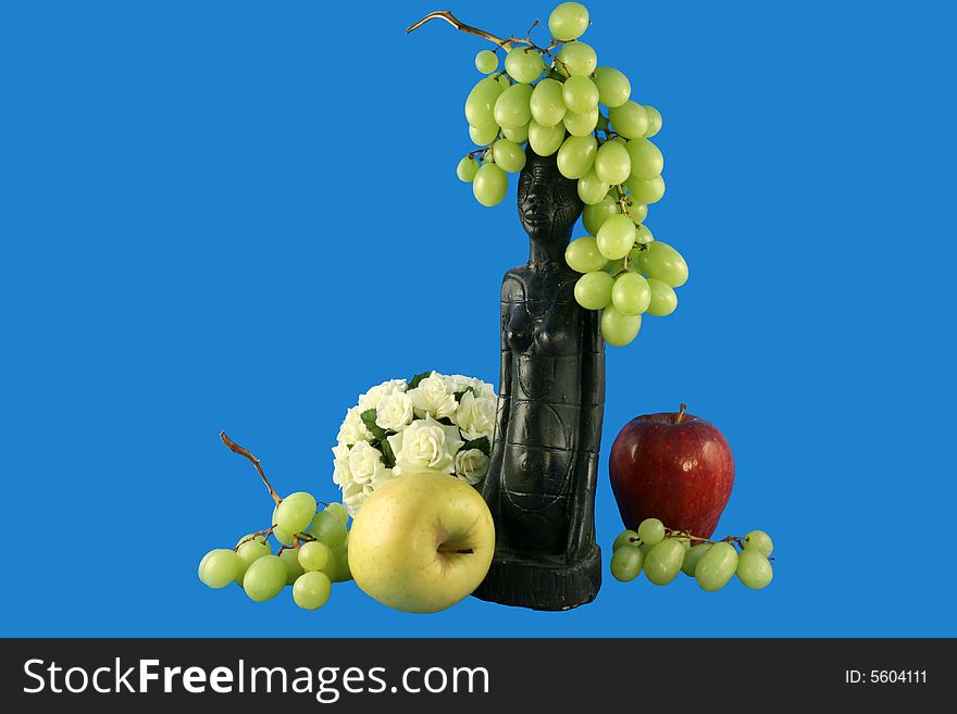 Fruit and sphere from flowers in a composition with a figurine. Fruit and sphere from flowers in a composition with a figurine