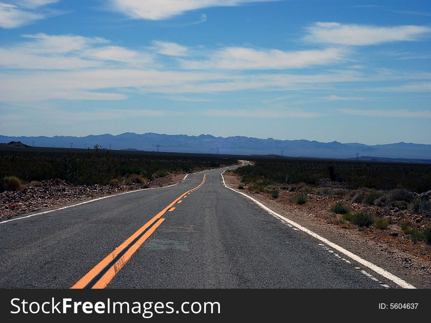 An empty road cuts through the California desert. An empty road cuts through the California desert.