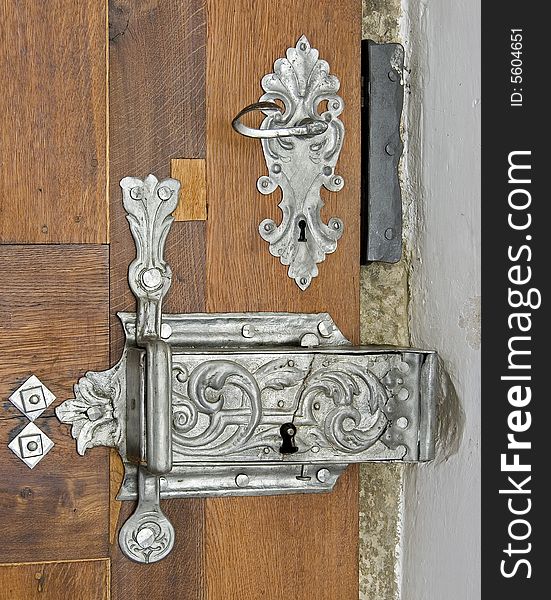 Vintage toreutic lock on wooden door. Vintage toreutic lock on wooden door