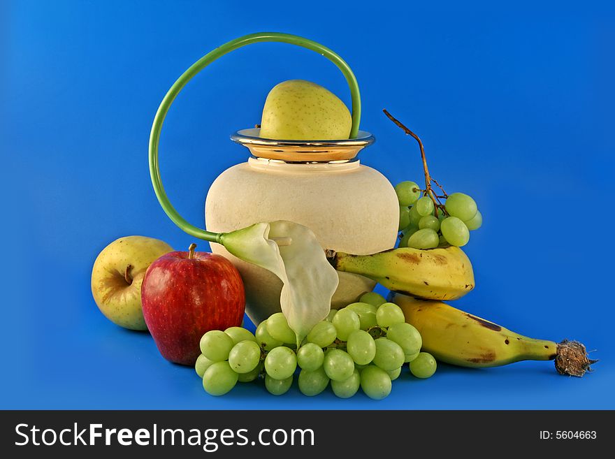 Fresh fruit and flowers in a cream vase. Fresh fruit and flowers in a cream vase