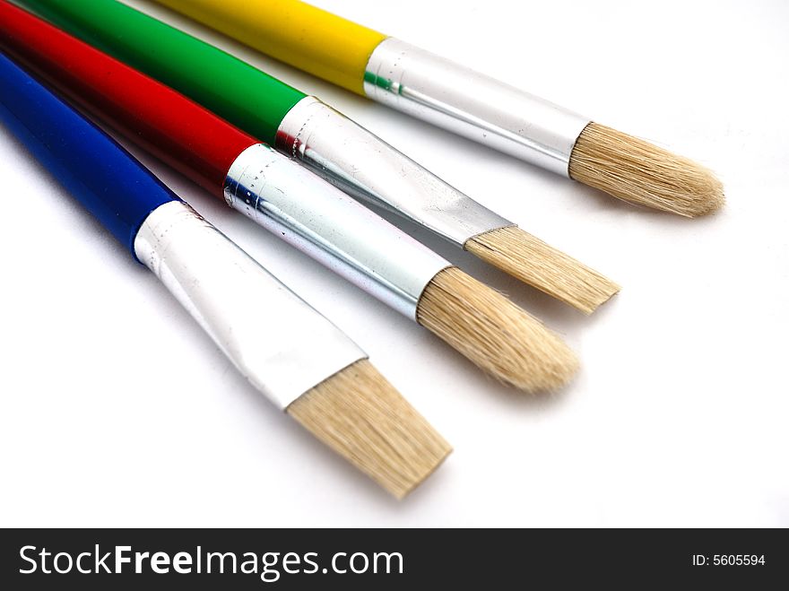 Large paint brushes on a white background.