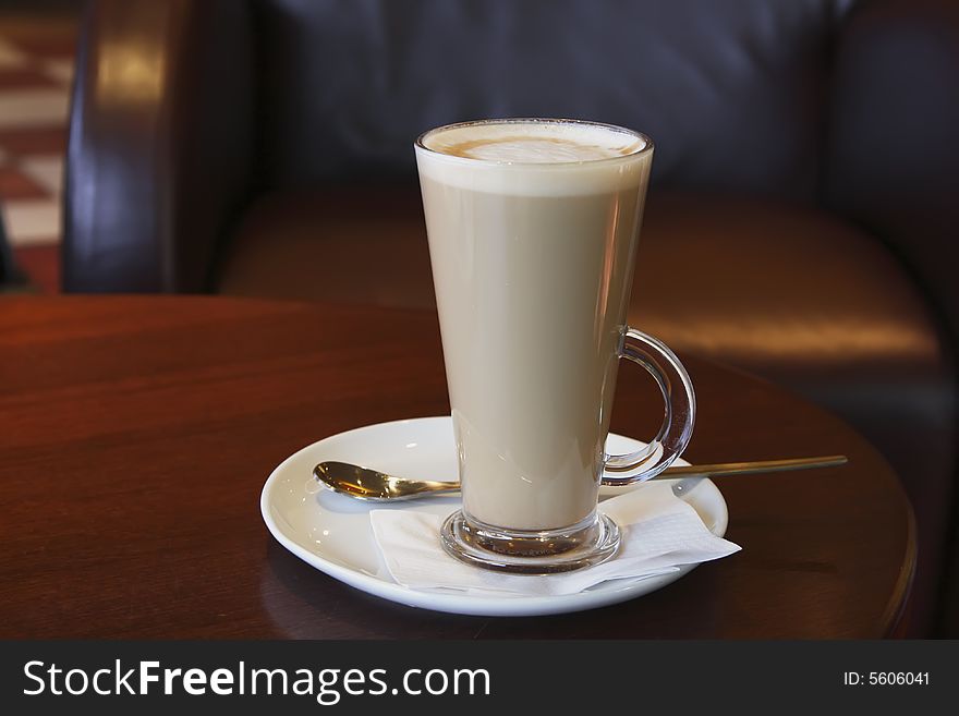 Coffee - Latte Cappuccino in a tall glass on cafe background