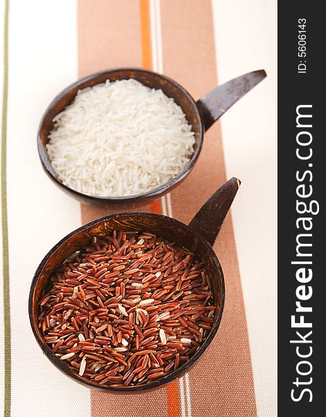 Himalayan Red Long grain and white Rice in coconut bowl on tablecloth, shallow DOF