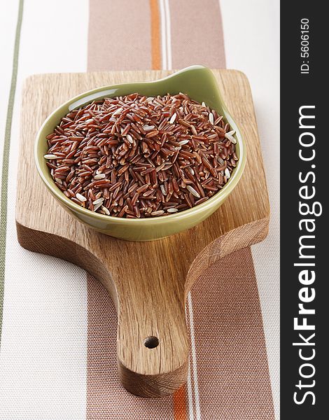 Himalayan Red Long grain Rice in green bowl on wooden board