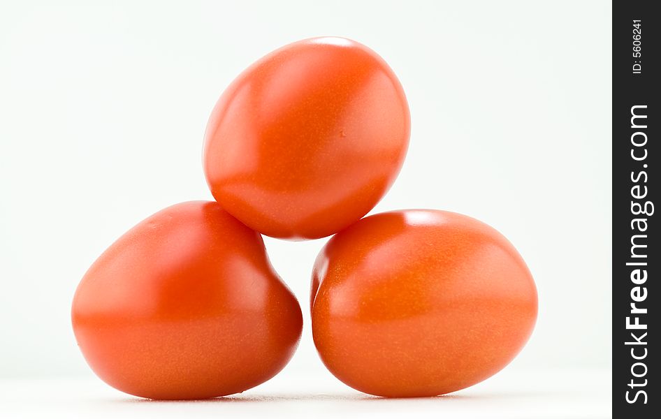 A stack of fresh summer tomatoes isolated on white. A stack of fresh summer tomatoes isolated on white.