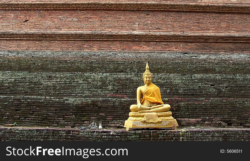 Thai Buddha statue on a stupa's wall background