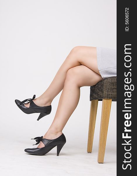 Woman in sexy shoes sitting on the chair