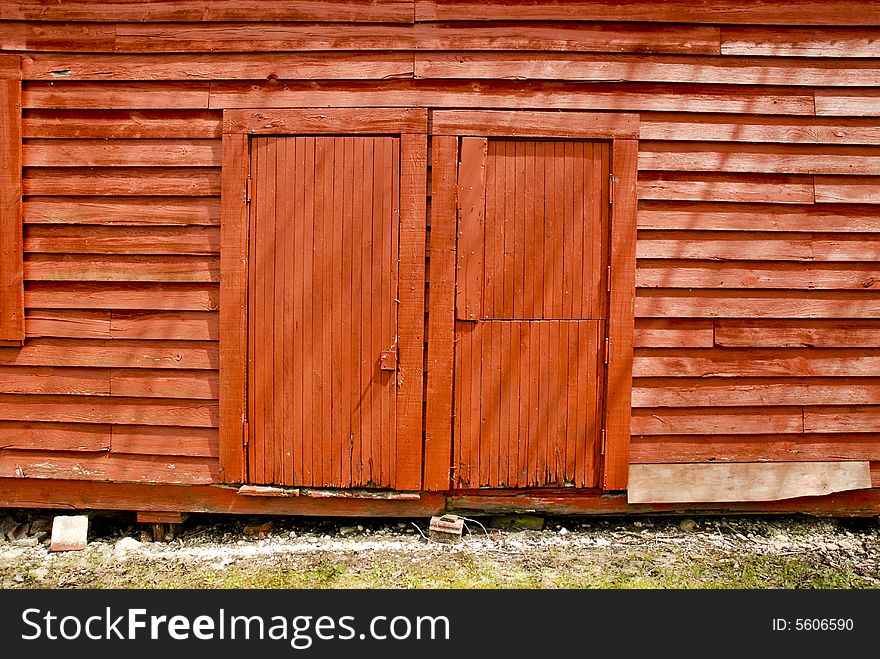Old, red wooden barn side doors in sunlight. Old, red wooden barn side doors in sunlight