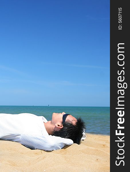 Man lie down on tropical beach sand