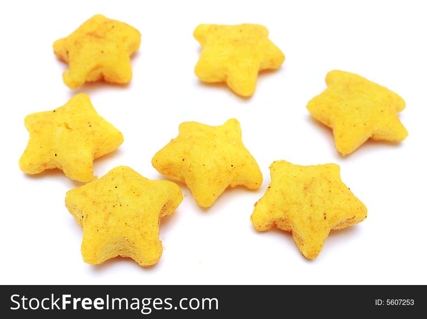 A pile of yellow snacks in star shape on white background. A pile of yellow snacks in star shape on white background.