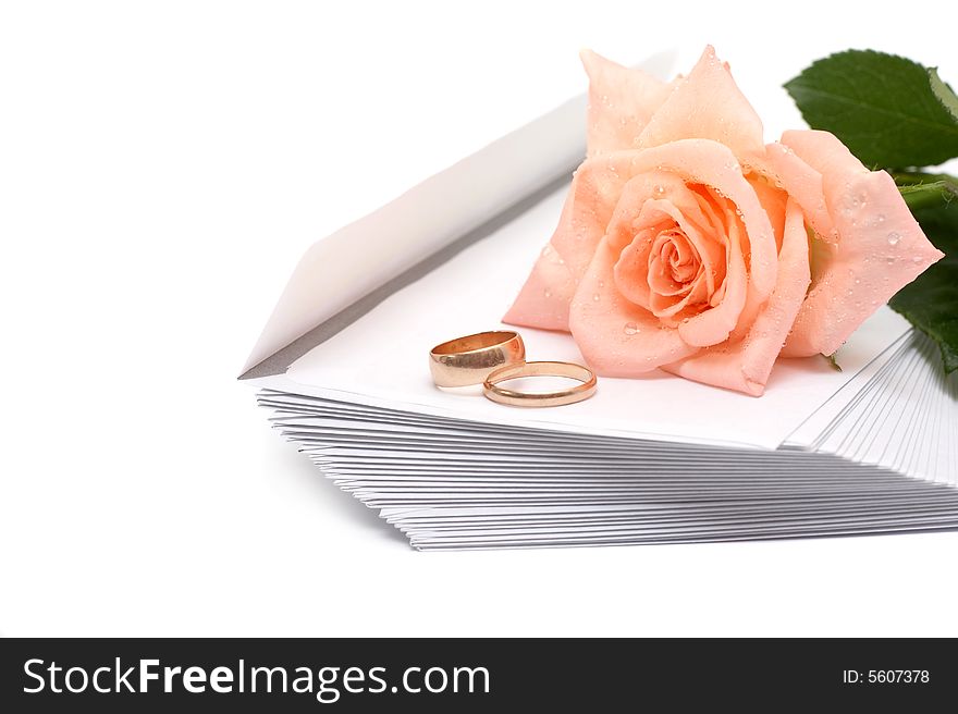 Rose, envelopes and rings on a white background