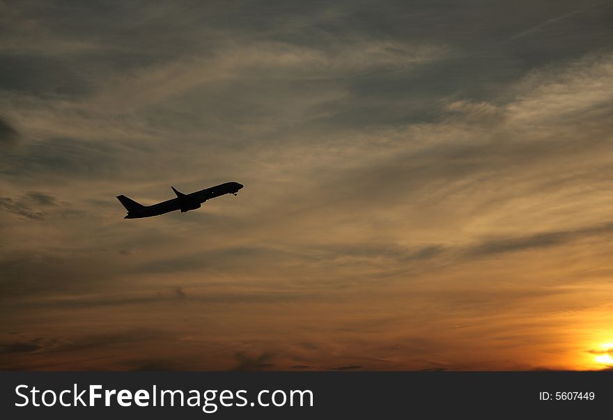 A sleek jet departs at sunset. A sleek jet departs at sunset