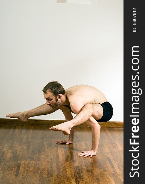 Man performing yoga. Arms supporting body, legs and feet draped over shoulders. Vertically framed shot. Man performing yoga. Arms supporting body, legs and feet draped over shoulders. Vertically framed shot.