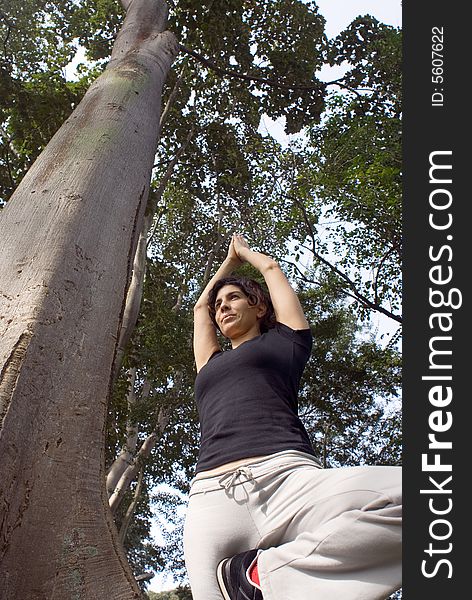 Woman in Yoga Pose Next to Tree in Park - Vertical