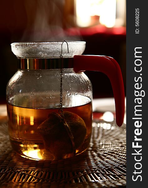 Glass teapot early morning on the straw table mats. Glass teapot early morning on the straw table mats