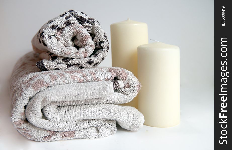 Nordic design towels with a warm beige colour and cream candles for a cleansing and relaxing bath or spa treatment. Nordic design towels with a warm beige colour and cream candles for a cleansing and relaxing bath or spa treatment