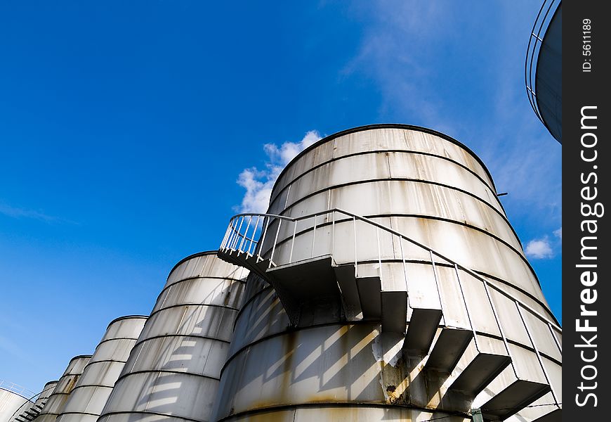 Spiral staircase up a industrial cylindrical tank to access its roof. Spiral staircase up a industrial cylindrical tank to access its roof